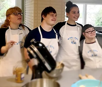 W.A.G. Able interns smiling together in the kitchen while baking treats
