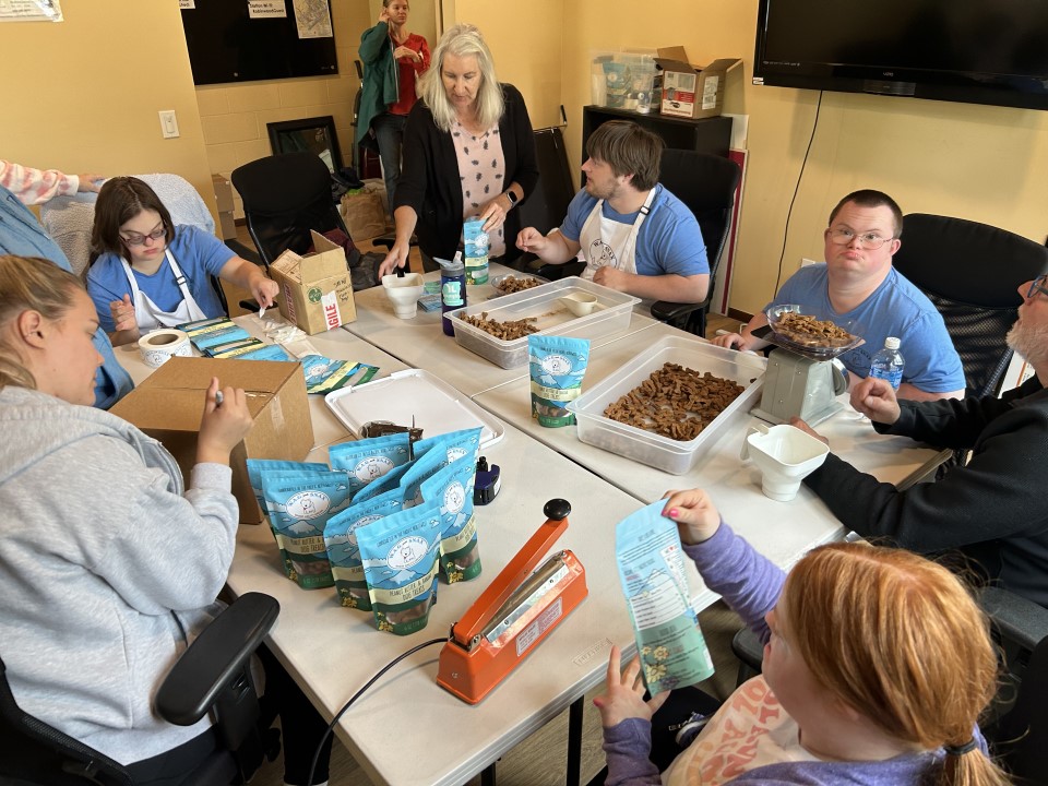 W.A.G. Able interns packaging treats together around a table