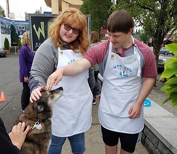 Interns Sarah and Daniel greeting a dog at a W.A.G. Able event